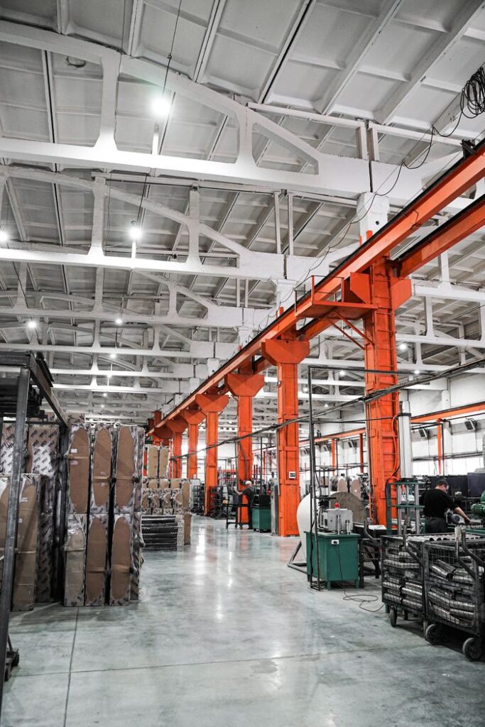 Spacious industrial plant interior featuring machinery and metal frames with a high ceiling.